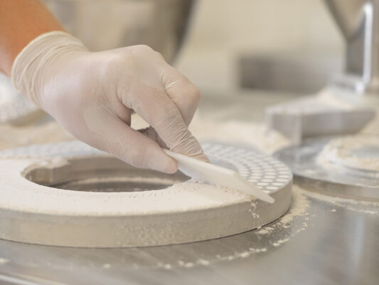 Befüllung einer Kapselplatte mit Pulverrohstoff in der SEEWALD Produktion – Herstellung von Kapseln