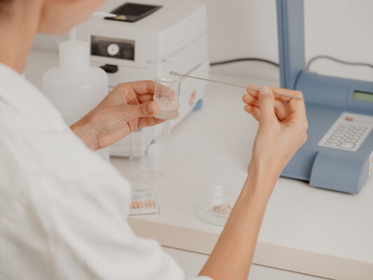 Laborarbeit in der SEEWALD Produktentwicklung – Frau dosiert Pulverprobe mit Spatel